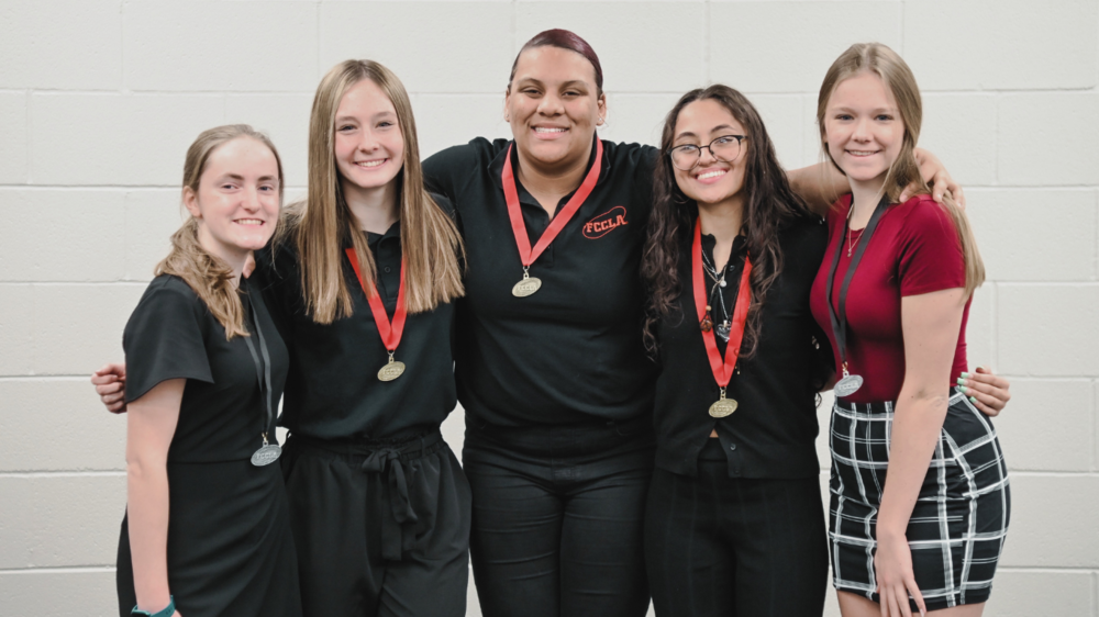 5 Students posing with their red medals