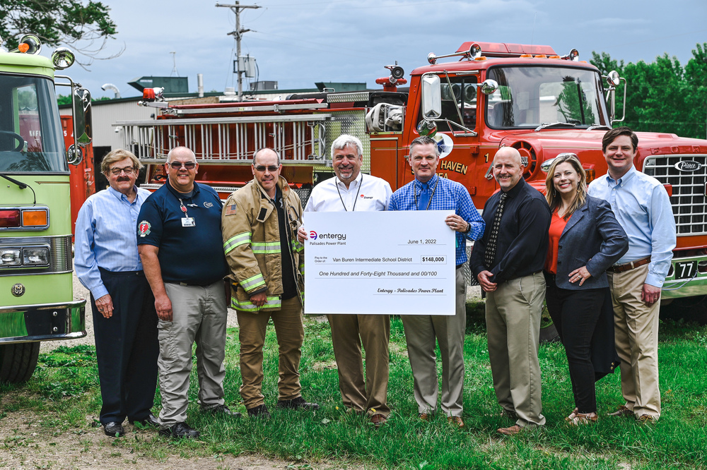Photo of adults holding check in front of fire engine