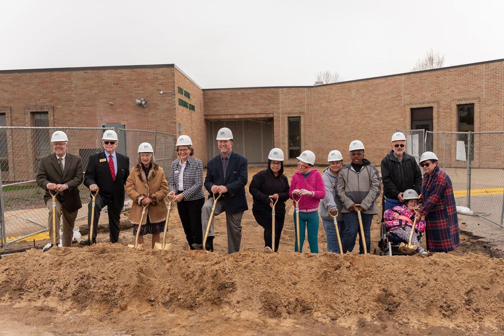 Photo of School Board Members, Administration, Staff, and Students with shovels and helmets during  in front of the Bert Goens Learning Center